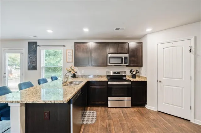 a kitchen with granite countertop a sink stove and refrigerator