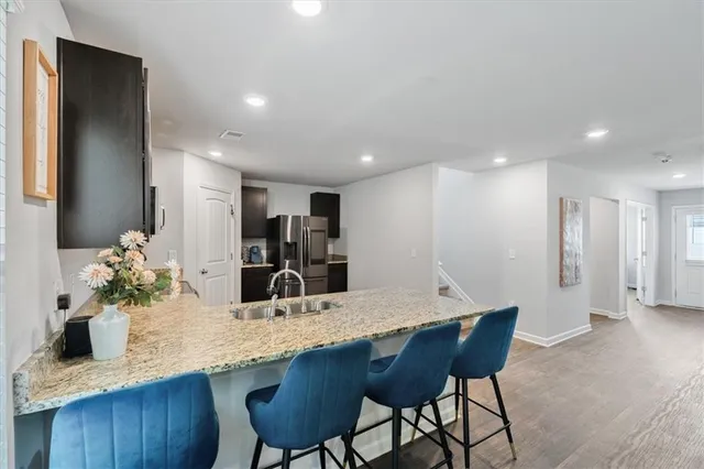a kitchen with granite countertop kitchen island a table and chairs in it