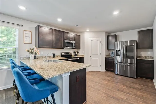 a kitchen with stainless steel appliances granite countertop a sink refrigerator and microwave
