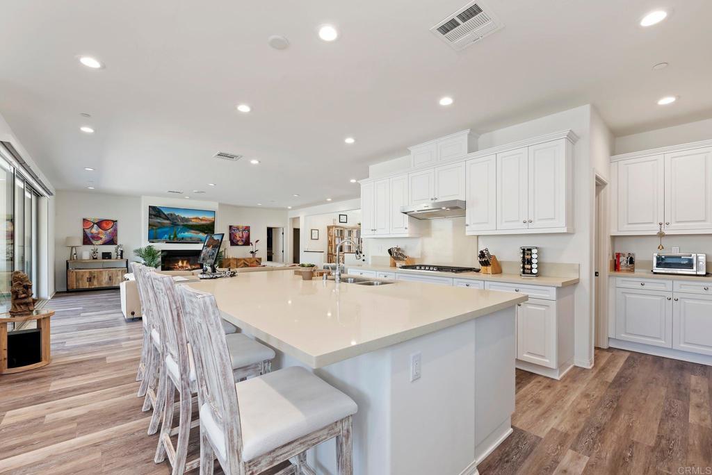 22089 Gallop Way Escondido, CA 92029 - Photo 11 of 43 a kitchen with a dining table chairs refrigerator and cabinets