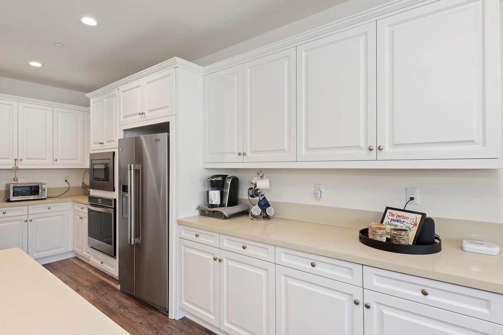 22089 Gallop Way Escondido, CA 92029 - Photo 13 of 43 a kitchen with stainless steel appliances white cabinets and a refrigerator