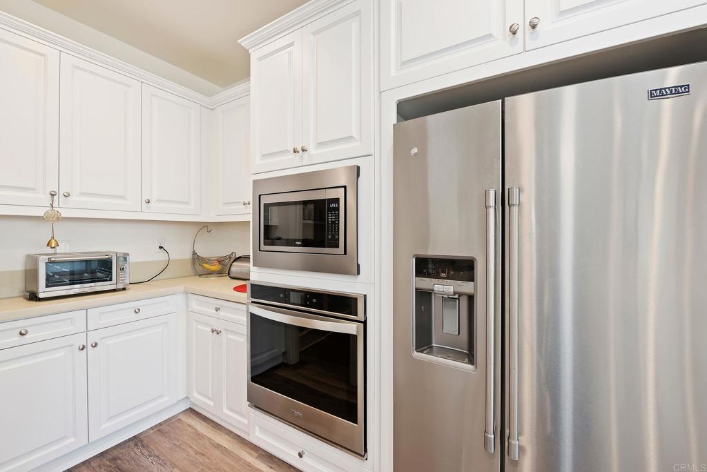 22089 Gallop Way Escondido, CA 92029 - Photo 14 of 43 a kitchen with stainless steel appliances white cabinets and a refrigerator