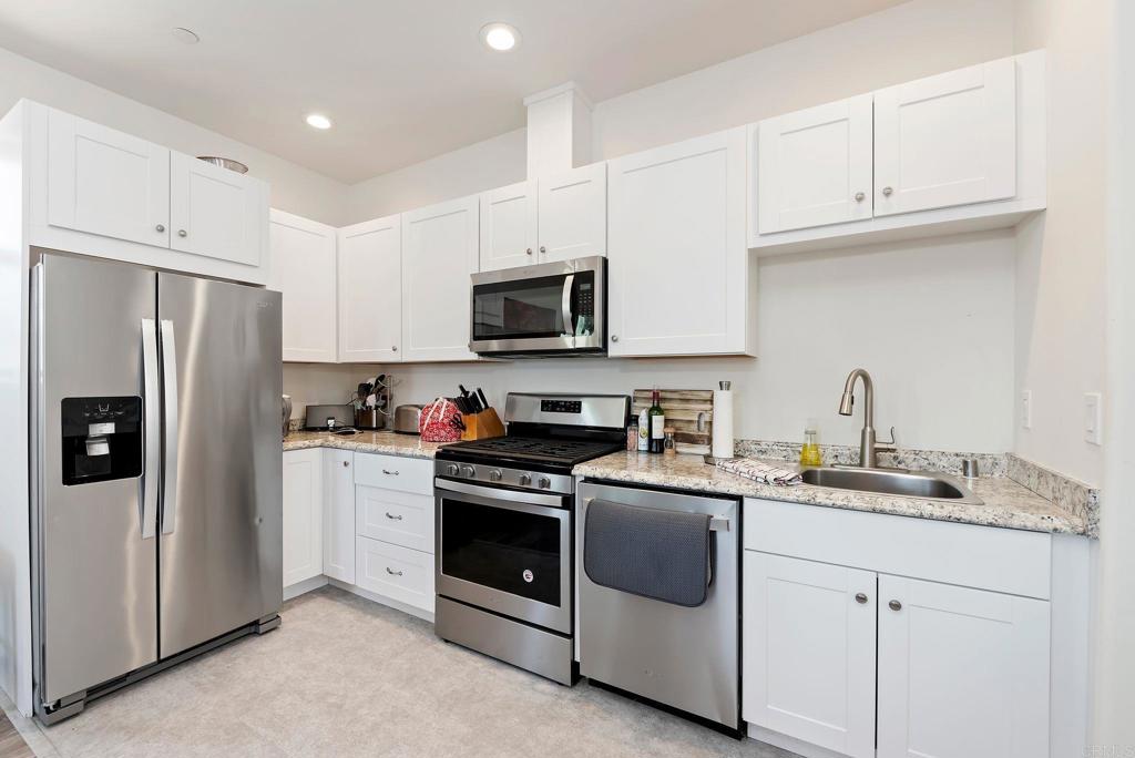 22089 Gallop Way Escondido, CA 92029 - Photo 26 of 43 a kitchen with cabinets stainless steel appliances and a sink