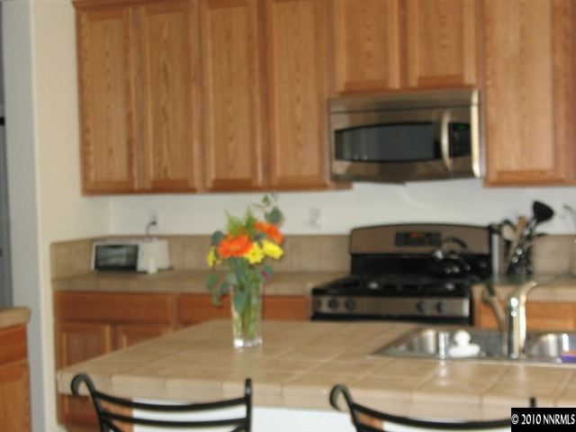 10612 Fire Poppy Circle Reno, NV 89521 - Photo 4 of 9 a kitchen with a stove and a white cabinets