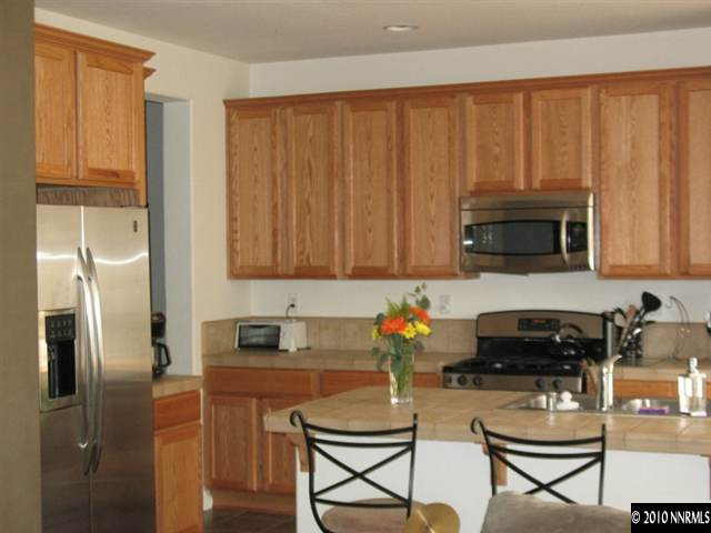 10612 Fire Poppy Circle Reno, NV 89521 - Photo 5 of 9 a kitchen with a refrigerator stove and microwave