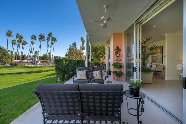 a living room with patio furniture and a garden
