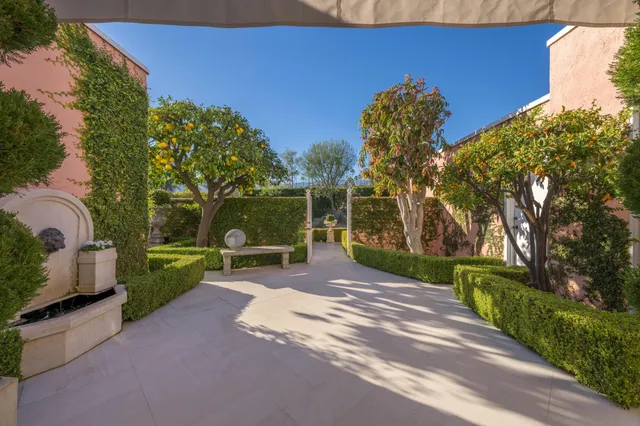 a view of a chairs and table in the patio next to a yard