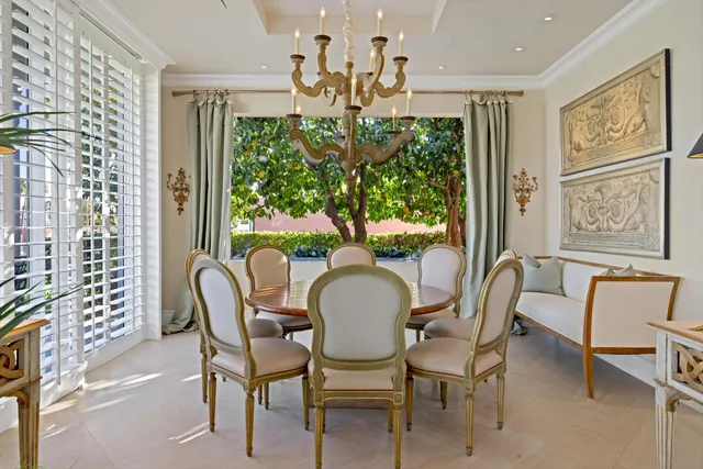 a dining room with furniture a large window and a chandelier