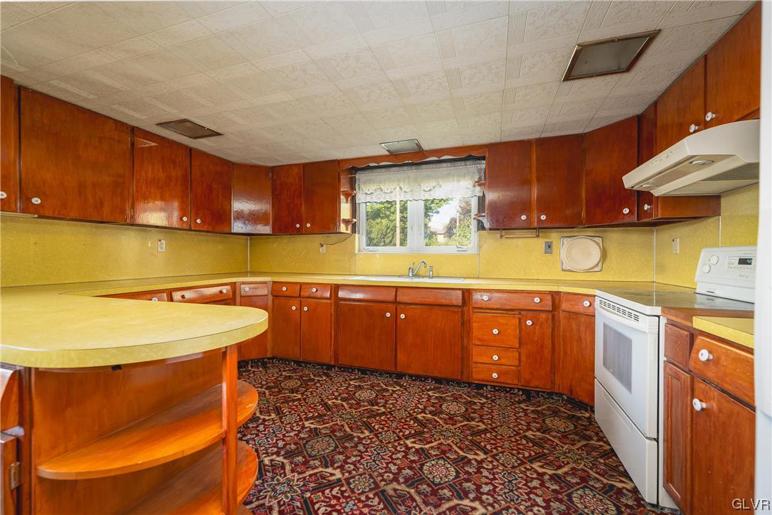 6991 Hilltop Road Allentown, PA 18106 - Photo 2 of 26 a kitchen with a sink and wooden cabinets