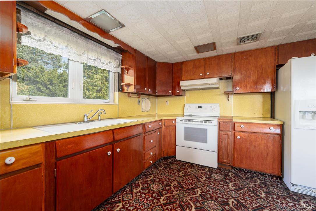 6991 Hilltop Road Allentown, PA 18106 - Photo 3 of 26 a kitchen with a sink cabinets stainless steel appliances and a window