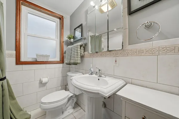 a bathroom with a sink a toilet and mirror