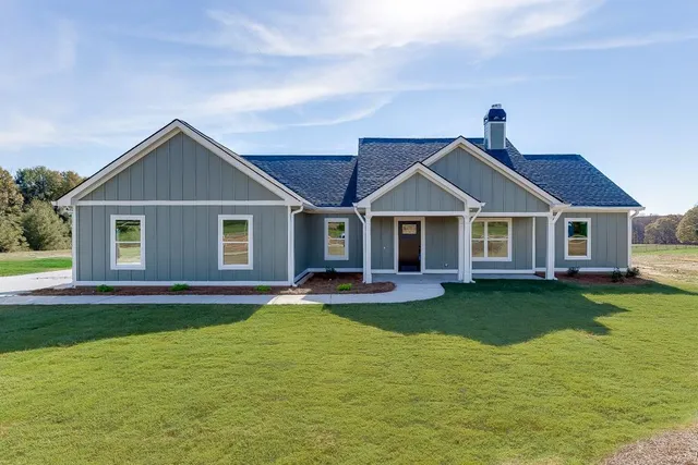 a front view of a house with a garden and deck