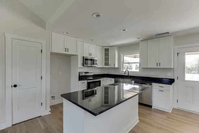 a kitchen with granite countertop a sink and cabinets