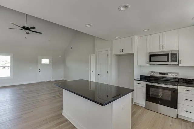 a kitchen with granite countertop a sink and stainless steel appliances