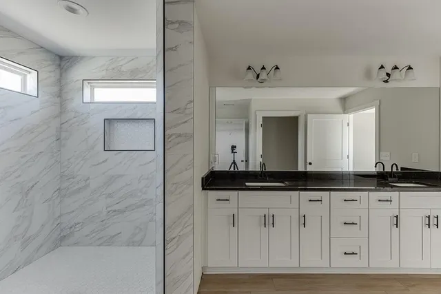 a bathroom with a granite countertop sink and a mirror