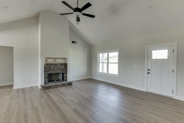 wooden floor fireplace and windows in an empty room