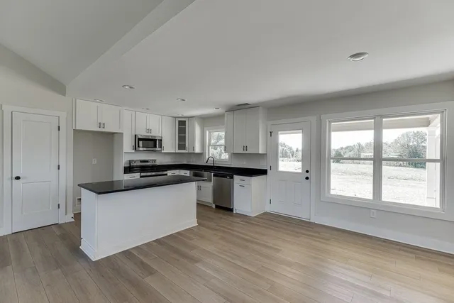 a kitchen with stainless steel appliances a sink a stove a refrigerator and cabinets