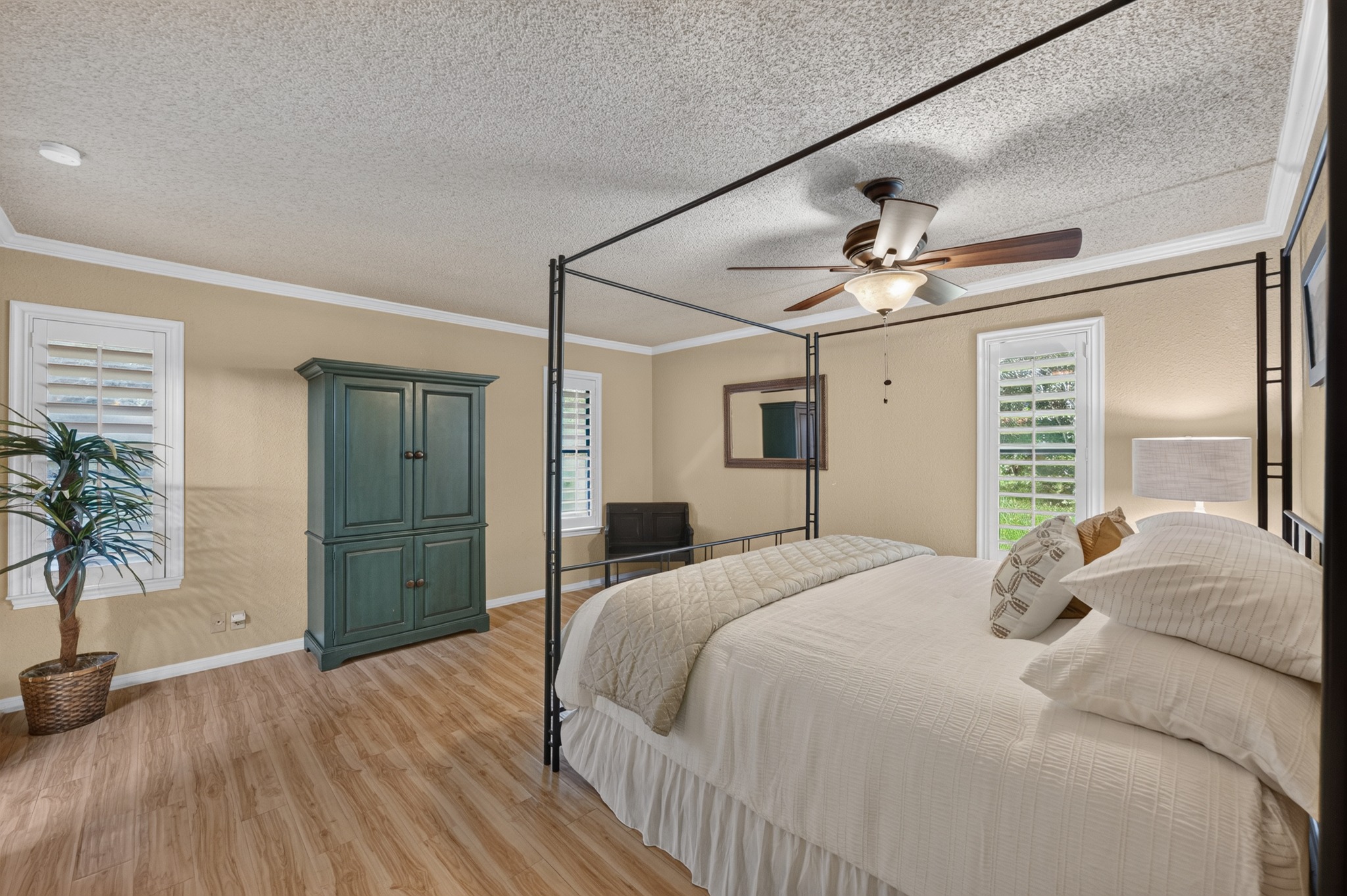 1907 Stoneridge Road Austin, TX 78746 - Photo 18 of 36 Spacious primary bedroom with multiple windows and easy-care flooring.