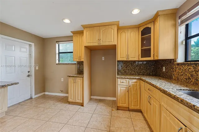 a kitchen with stainless steel appliances granite countertop a refrigerator and a stove top oven