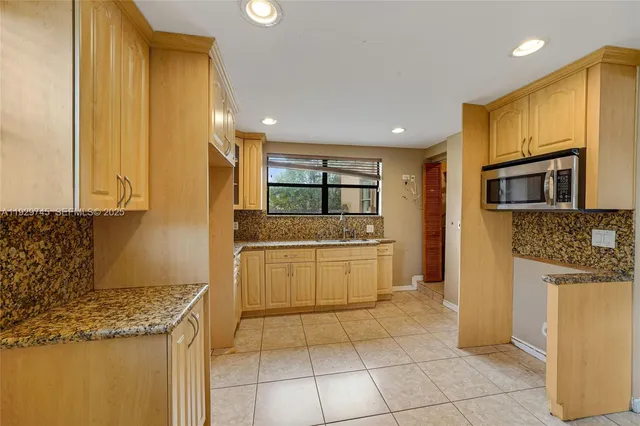 a kitchen with stainless steel appliances granite countertop a refrigerator and a stove top oven