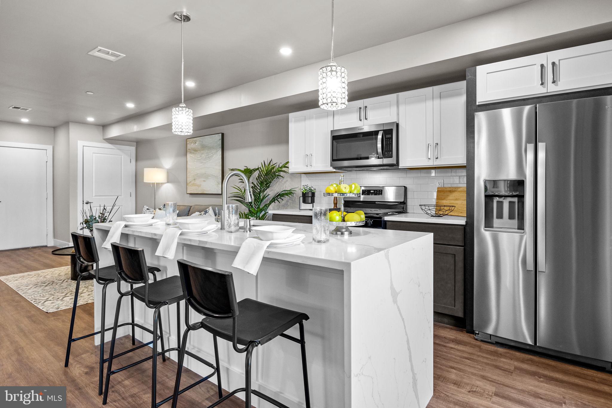 77 East Pastorius Street, Unit 1 Philadelphia, PA 19144 - Photo 12 of 43 a kitchen with stainless steel appliances a table chairs refrigerator and microwave
