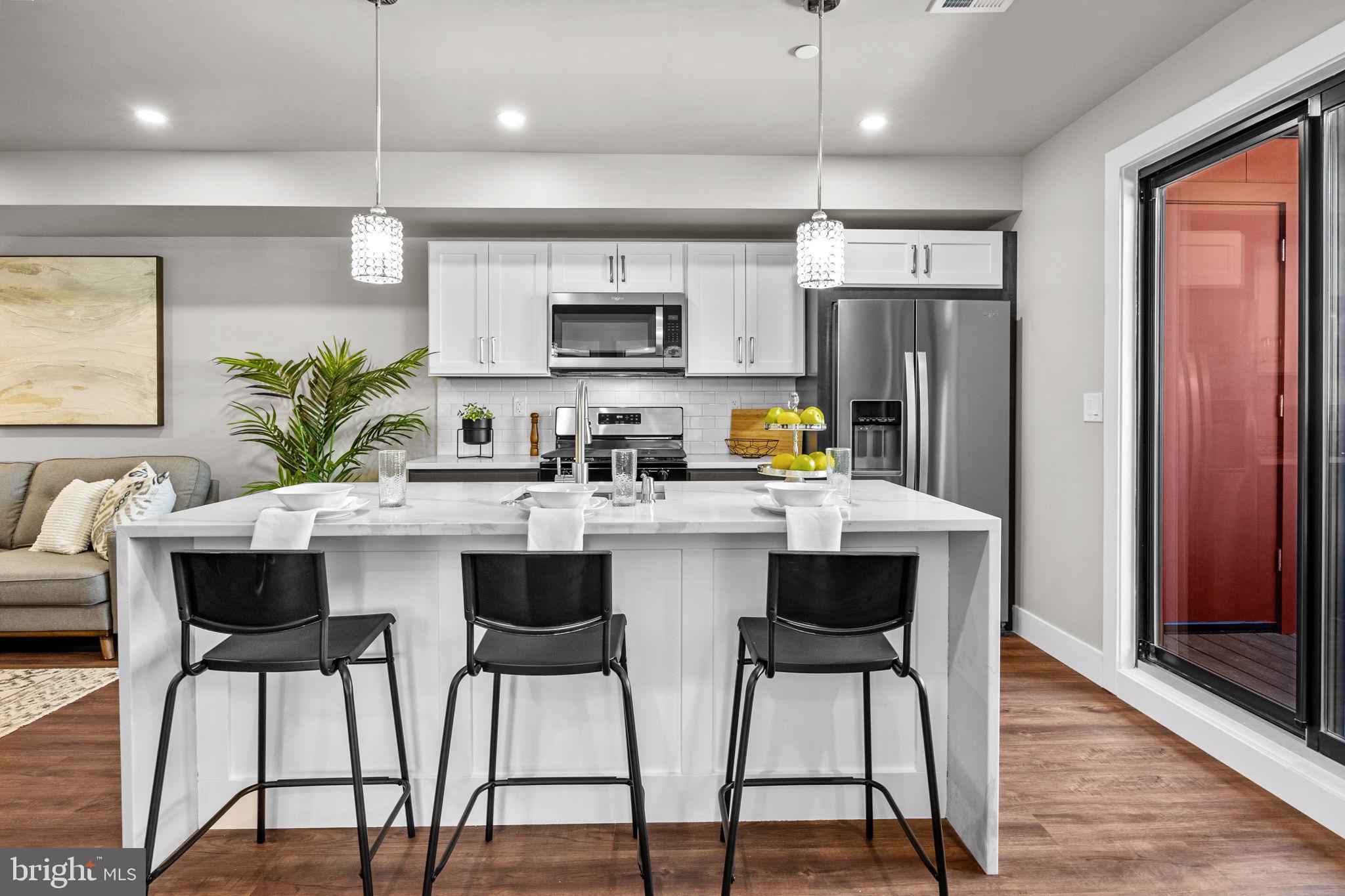 77 East Pastorius Street, Unit 1 Philadelphia, PA 19144 - Photo 13 of 43 a kitchen with stainless steel appliances a dining table chairs refrigerator and sink