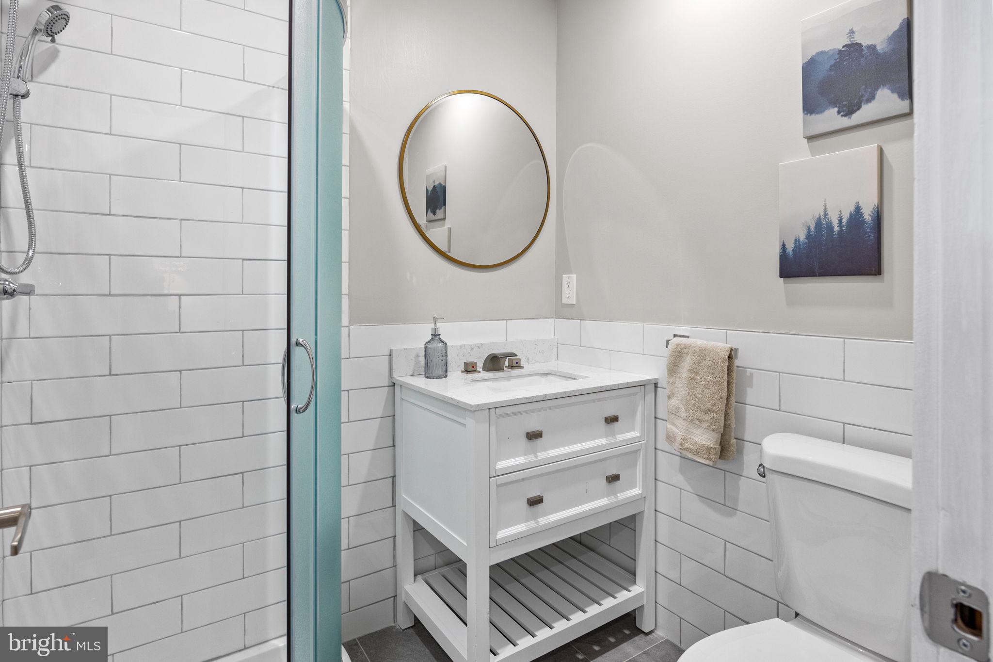 77 East Pastorius Street, Unit 1 Philadelphia, PA 19144 - Photo 14 of 43 a bathroom with a sink mirror vanity and toilet