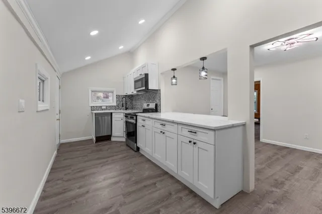 a large kitchen with stainless steel appliances granite countertop a stove and a sink