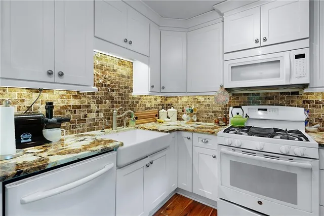 a kitchen with cabinets appliances a sink and a counter top space