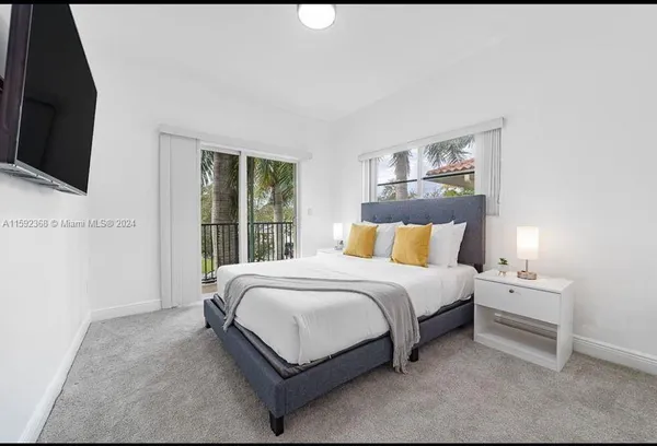 a large bed sitting in a bedroom next to a window