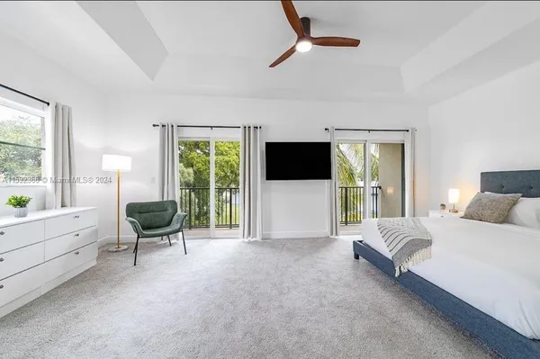 a spacious bedroom with a bed and a television