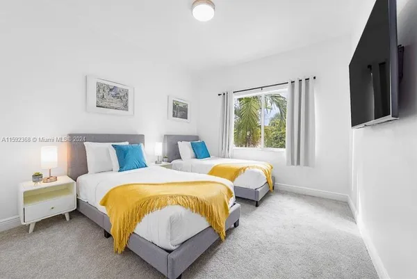 a spacious bedroom with a bed and a flat screen tv