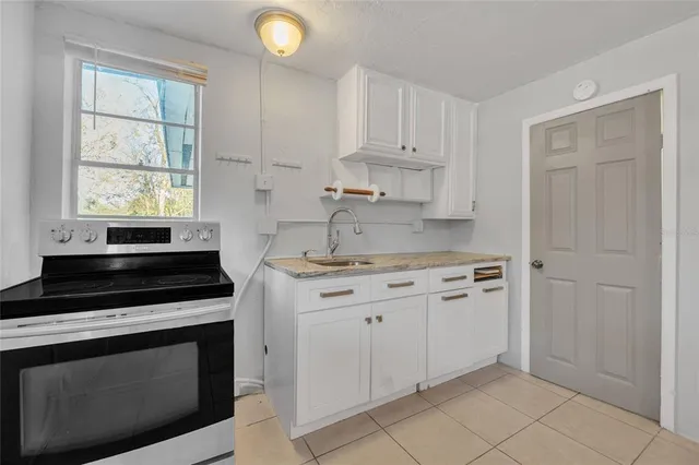 a kitchen with granite countertop white cabinets stainless steel appliances and sink