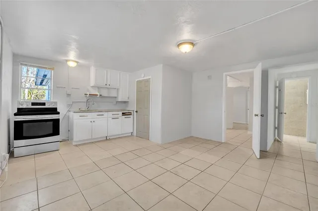 a view of a kitchen with white cabinets and white appliances