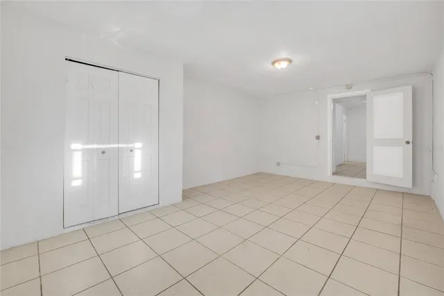 a view of an empty room and chandelier fan