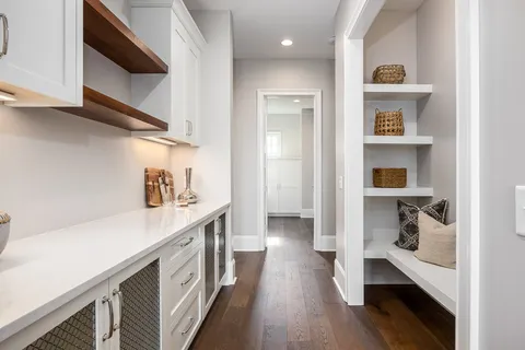 a view of a hallway with wooden floor and staircase