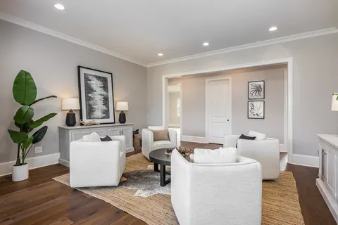 an empty room with wooden floor chandelier and windows