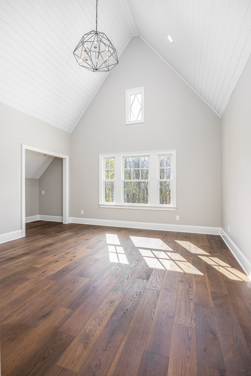 6876 Cross Keys Road College Grove, TN 37046 - Photo 51 of 99 an empty room with wooden floor chandelier and windows