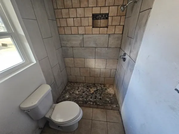a bathroom with a toilet and a shower