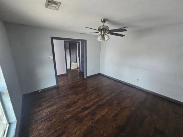 a view of a room with wooden floor and ceiling fan