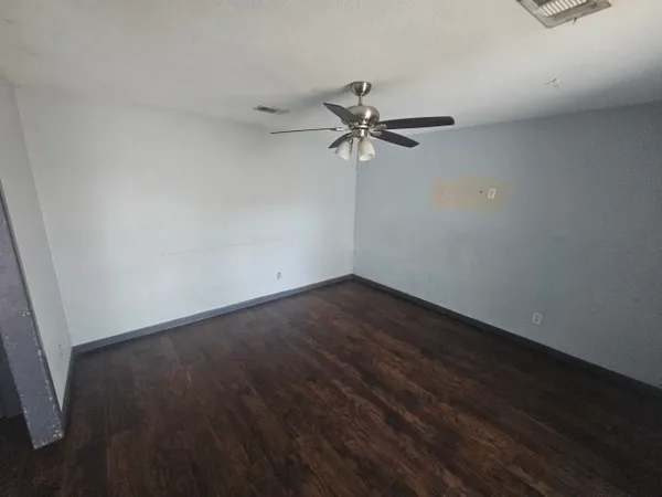 a view of a big room with wooden floor and fan