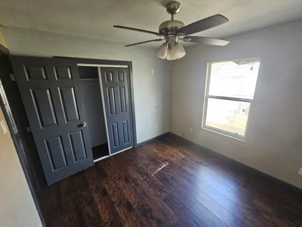a view of a hallway with wooden floor and chandelier