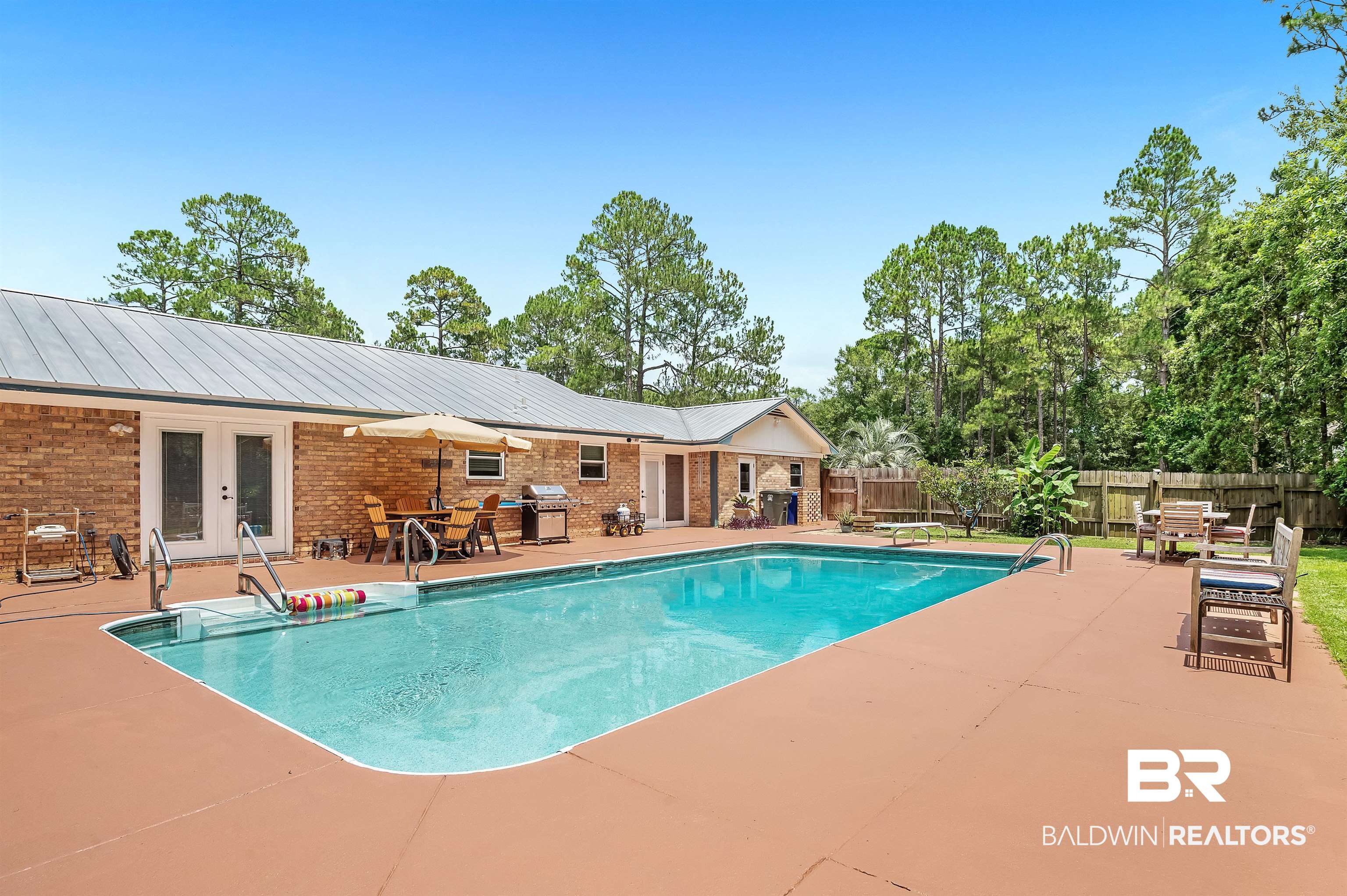 24551 Wolf Bay Drive Foley, AL 36535 - Photo 10 of 59 View of swimming pool featuring french doors, a patio area, a fenced backyard, grilling area, and outdoor dining area