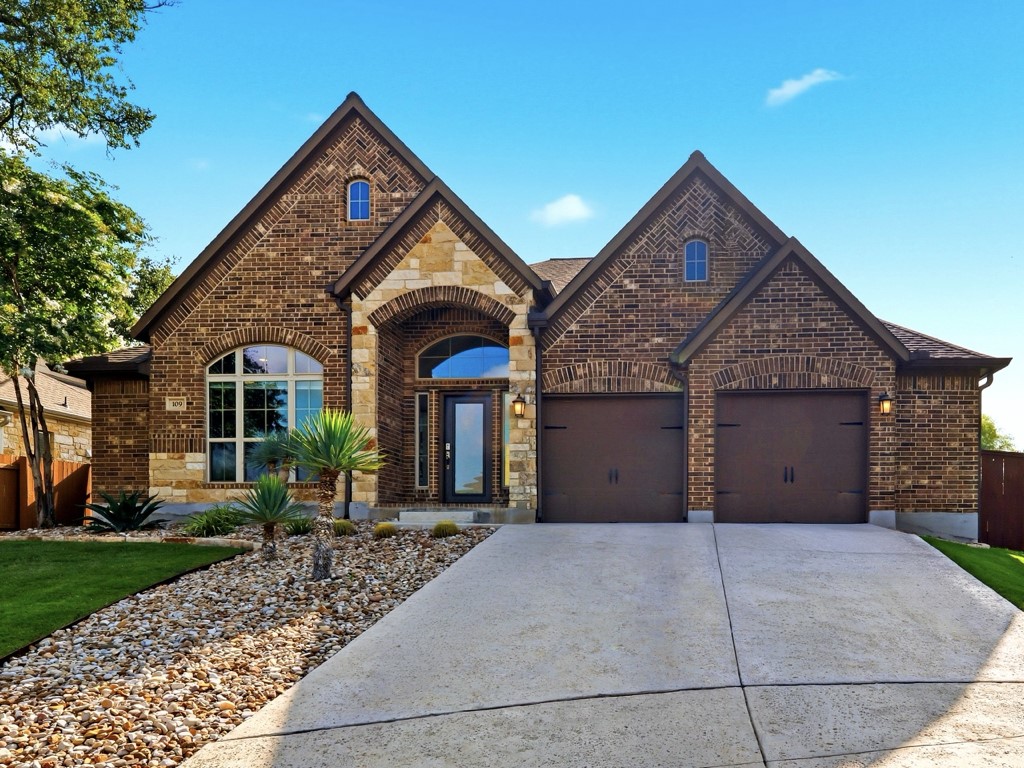 109 Lake Spring Circle Georgetown, TX 78633 - Photo 3 of 38 A classic brick and stone facade welcomes with twin gables and an inviting arched entry.