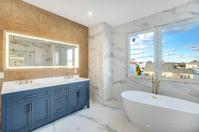 a spacious bathroom with a tub double sink and mirror