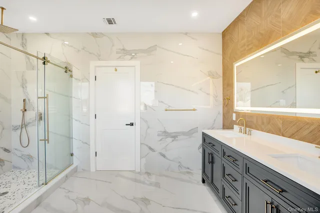 a bathroom with a double vanity sink mirror and shower
