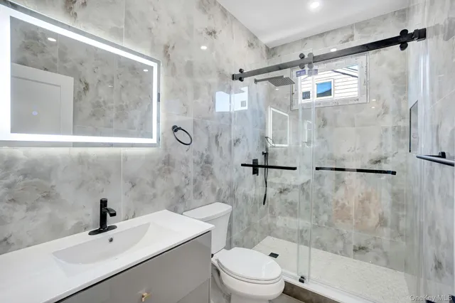 a bathroom with a bathtub shower sink vanity and toilet