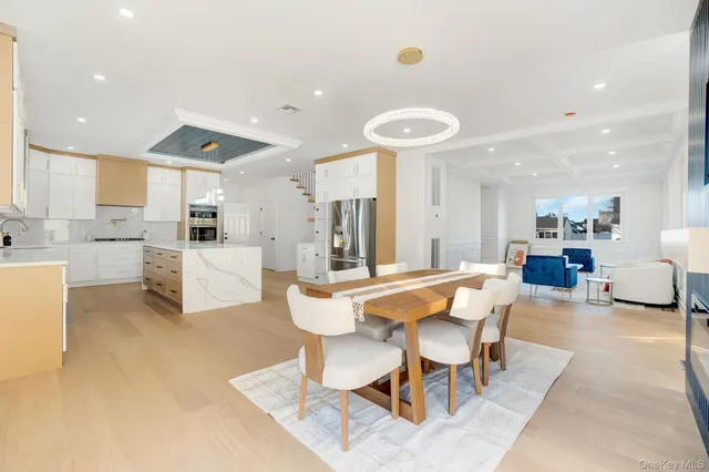 a dining room with stainless steel appliances kitchen island granite countertop a table and chairs