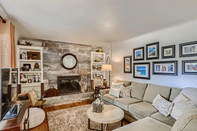 a living room with furniture a clock and a fireplace