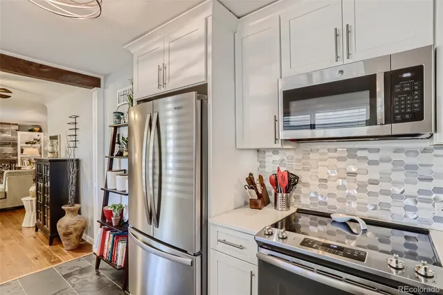 a kitchen with stainless steel appliances granite countertop a stove microwave refrigerator and sink